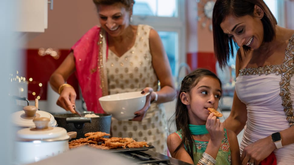 Closeup of three generations of women cooking for Diwali