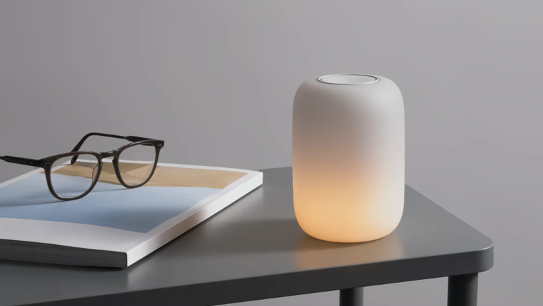 Lighted Casper Glow Light on a table next to a magazine and glasses.