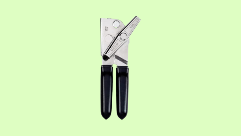 Can opener with black handles set against green background