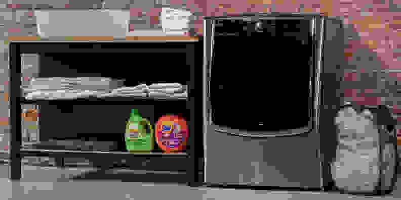 The LG WM9000HVA washing machine beside a laundry shelf.
