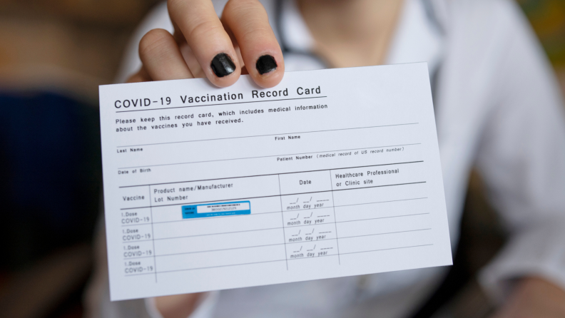 A doctor holds out a vaccination card for immunization records against coronavirus.