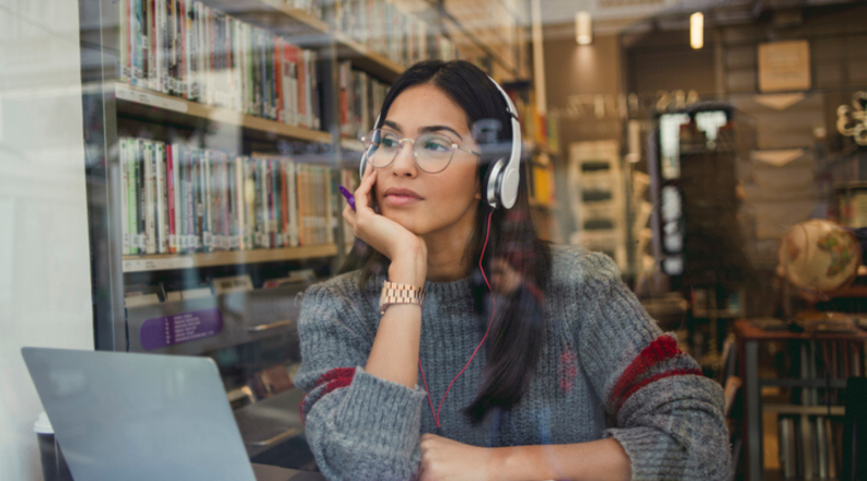 Woman with headphones on at bookstore