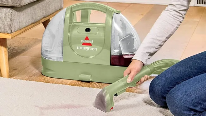 The Bissell Little Green Cleaner being used to clean a carpet.