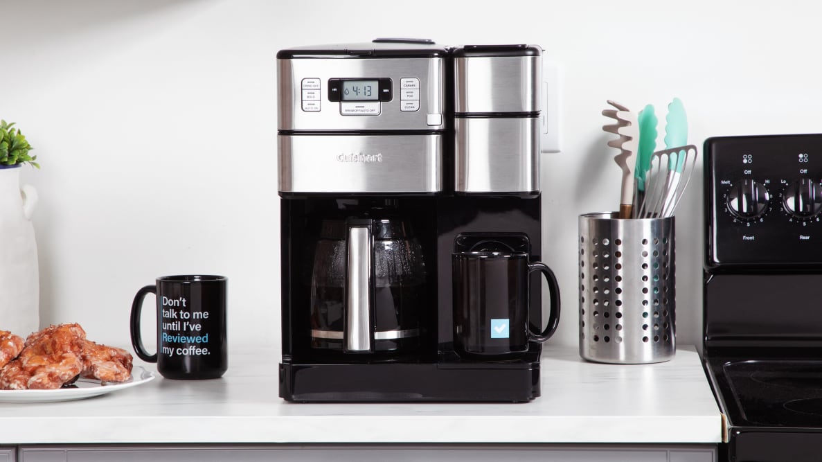 The Cuisinart coffee machine sitting on a kitchen counter beside a mug and pastries