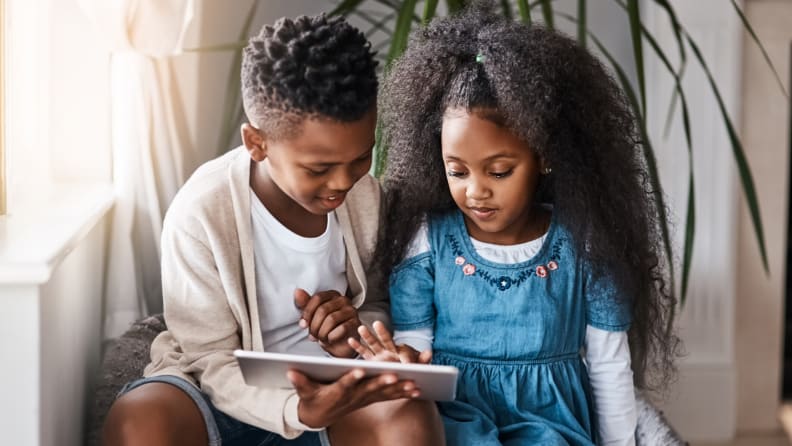 siblings using a tablet together