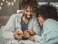 This couple looks joyful about supporting Black-owned businesses online.