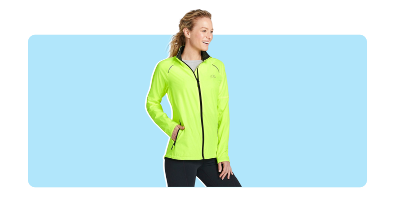 Model looks off to the side with hand on hip while wearing the neon yellow L.L.Bean Women's Bean Bright Multisport Jacket with black seams and black leggings..