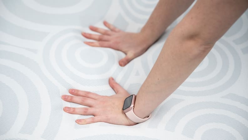 hands pushing onto serta mattress