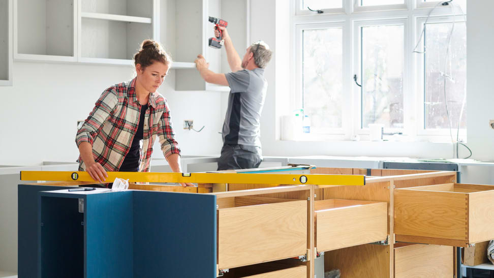 Man and woman working together to remodel kitchen.