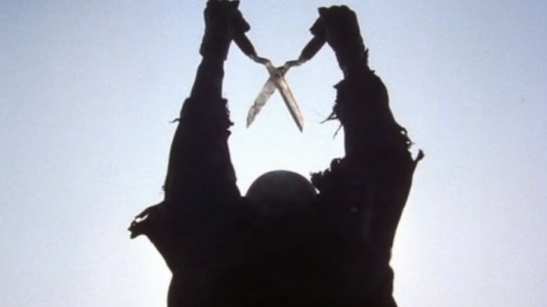A man in a shadow, holding a pair of clippers, in a scene from "The Burning."