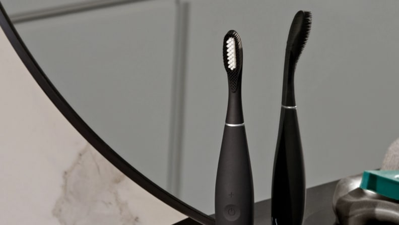 The Foreo Issa 3 electric toothbrush sitting in front of a bathroom mirror