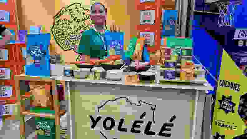 Person standing in front of Yolele stand at Expo West
