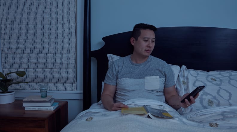 Parent on phone in bed
