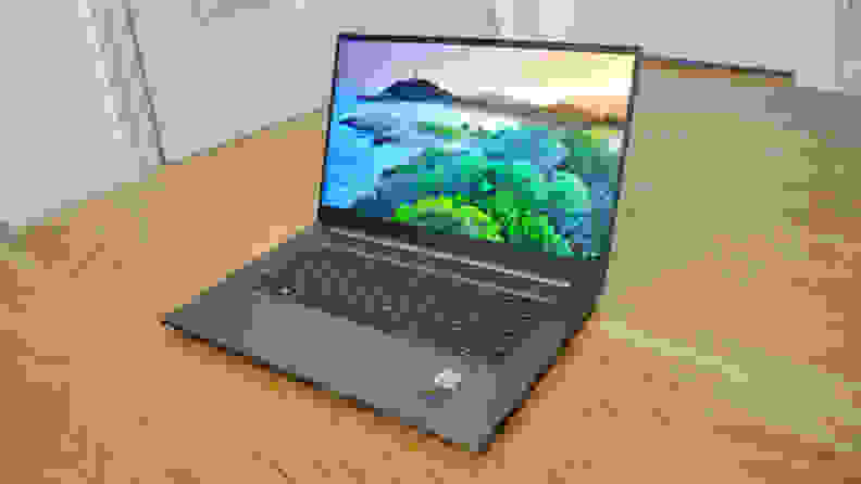 An open laptop sitting on a hardwood floor