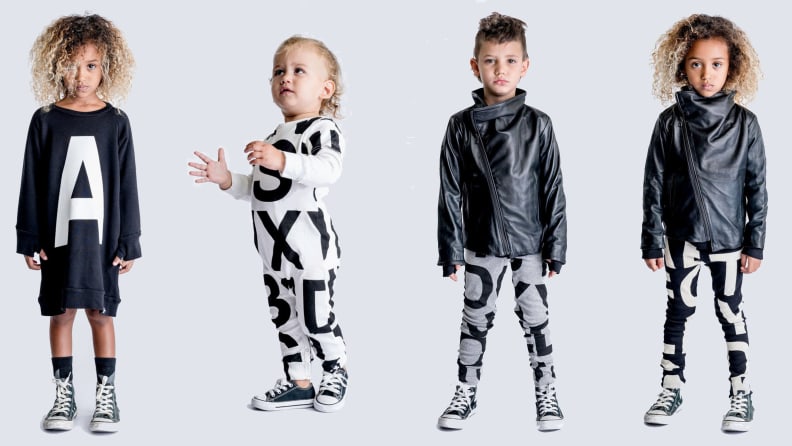 Four child models lined up next to each other. Left child is staring at camera, Black girl, wearing a black