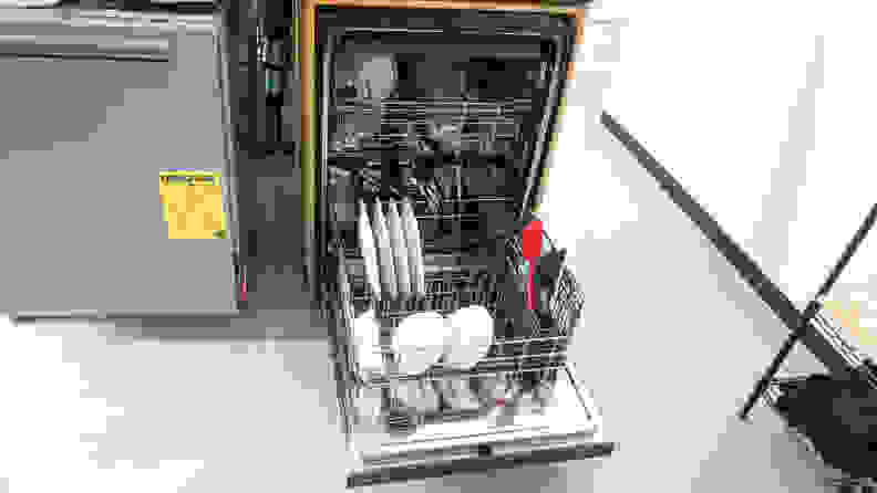 A close-up of the dishwasher installed in our testing labs, open with its racks pulled out, full of clean dishes.