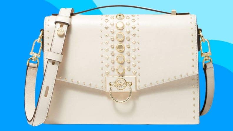 White leather satchel bag in front of blue background.