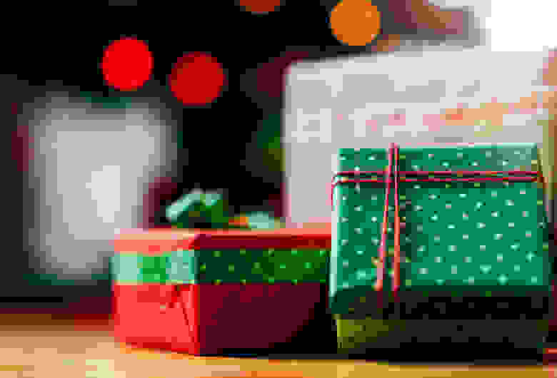 红色和绿色的节日礼盒，背景是闪烁的灯光。