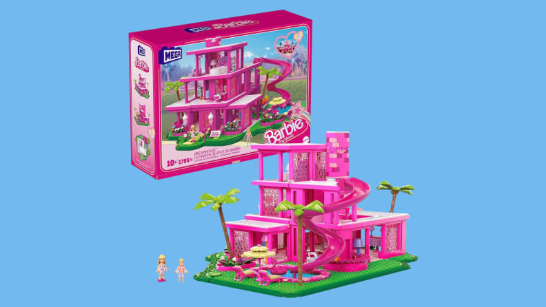 The pink-hued Mega Barbie the Movie Building Toy next to its own package in front of a blue background.