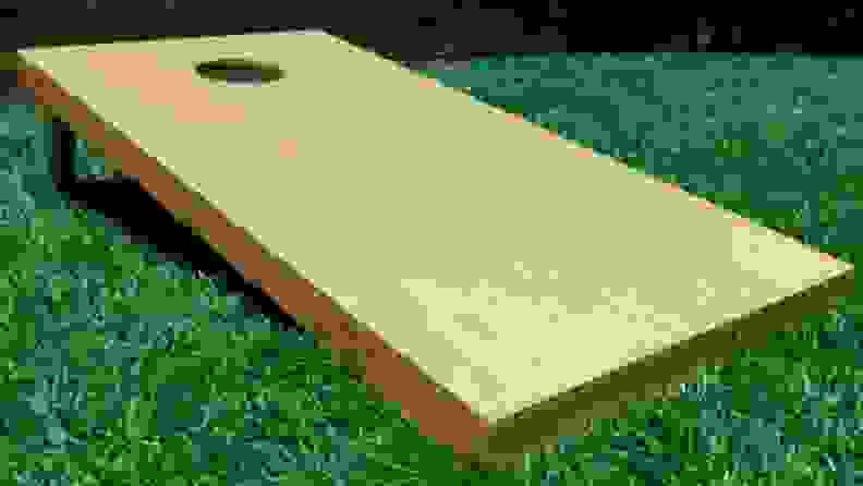 A cornhole board on a grassy field