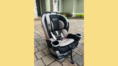 A Graco Extend2Fit 3-In-1 car seat, outside a house on a driveway.