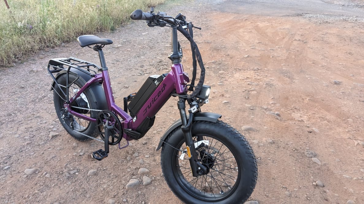 A purple, Juiced JetCurrent Pro e-bike, parked outside on a dirt road.