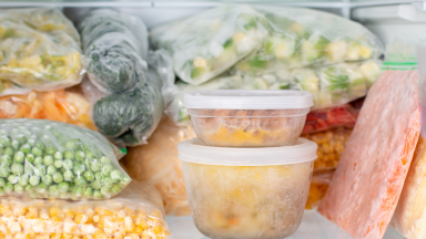 A neatly stacked freezer full of frozen vegetables