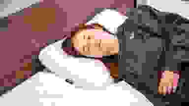 Person laying in bed with eyes closed on memory foam pillow.