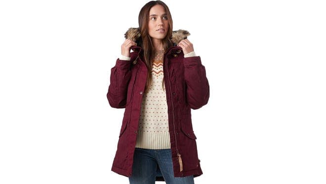 Person wearing burgundy winter jacket with fur around the hood.