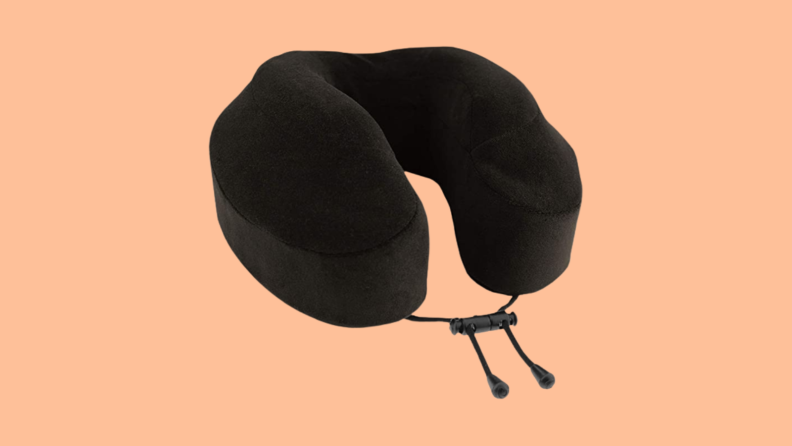 Black travel pillow against orange background