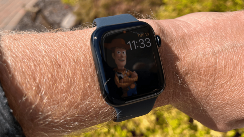 The Apple Watch SE (2022) is shown on a wrist with a Toy Story watch face.