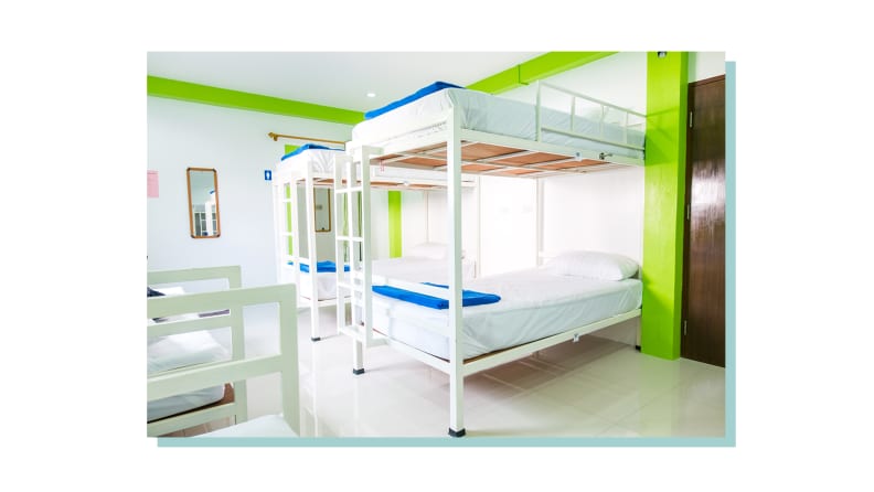 A hostel bedroom with many bunk beds.