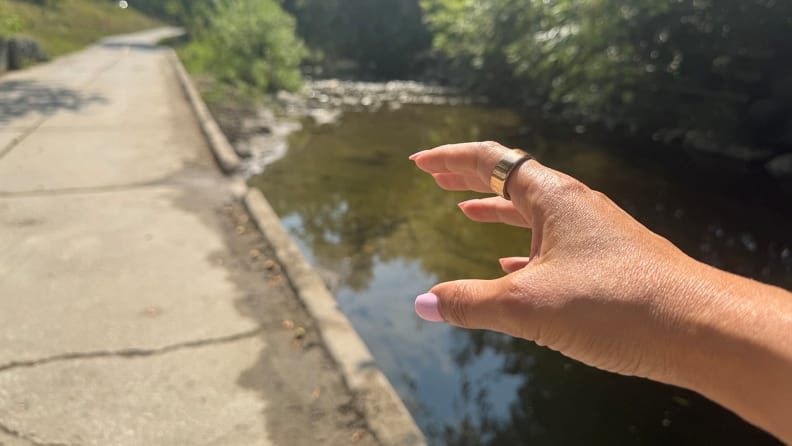 Oura Ring 4 on a finger of a person during a trail hike