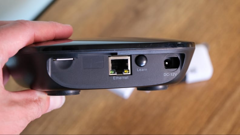 A hand holding the kit's base station.