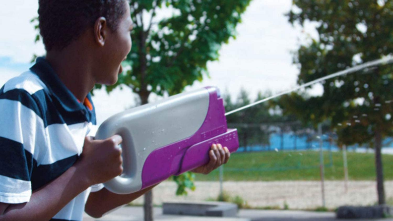 A child sprays water with a water gun.