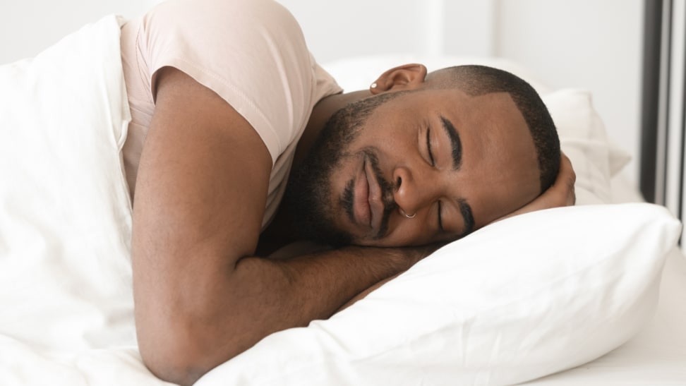 Black man sleeping peacefully with pillow