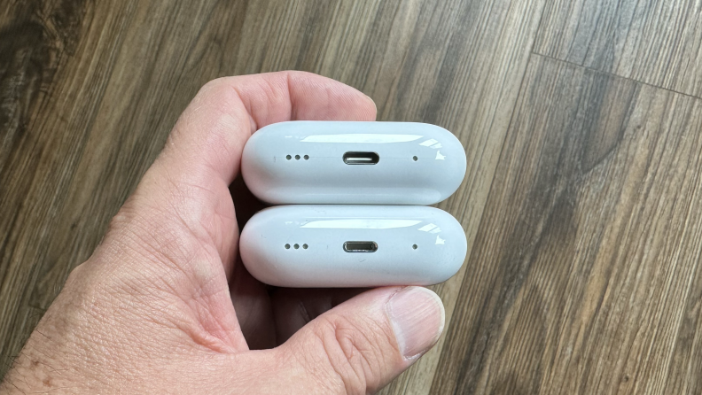 A hand holding the cases for the Apple AirPods Pro 2 with Lightning and with USB-C.