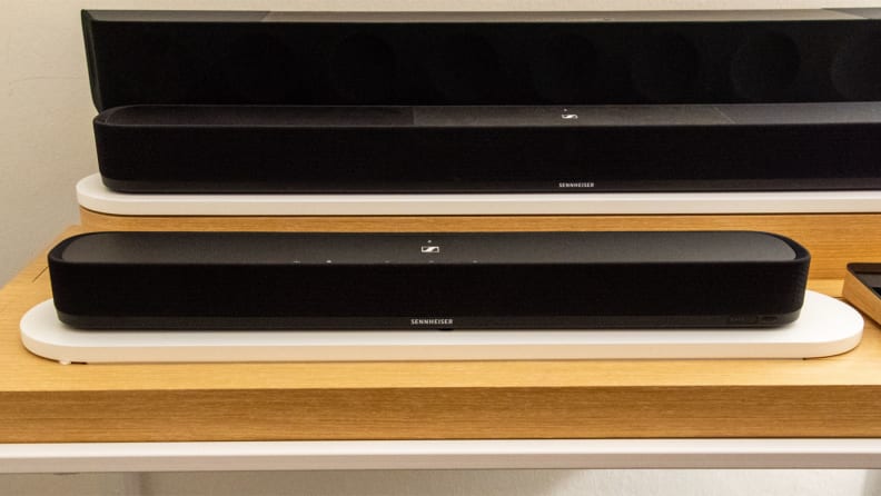 The Sennheiser Ambeo Soundbar Mini shown on a wood shelf for display.