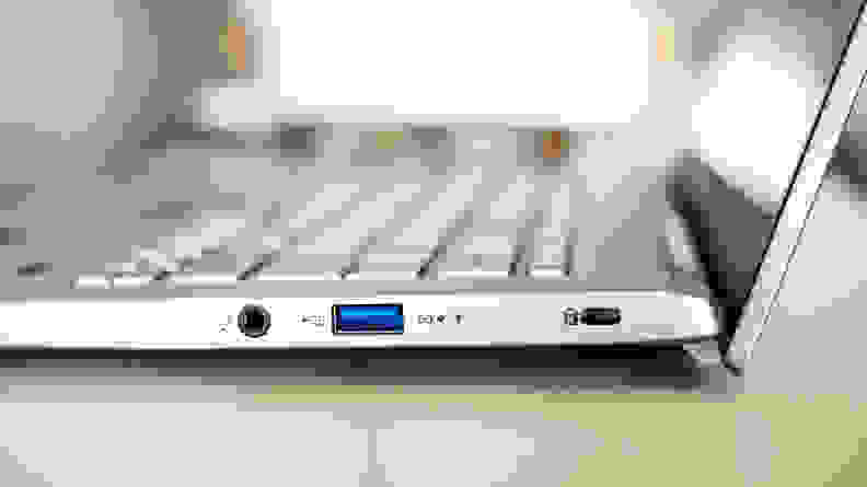 A close up of the connectivity ports the side of a silver laptop.