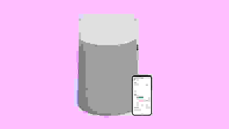 A gray, cylindrical Blueair Blue Pure 311i Max air purifier next to a cell phone that can control it with an app.