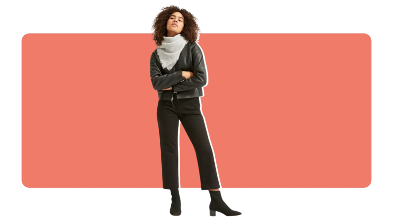 A model wearing a Everlane Cashmere Bandana with a leather jacket, a pair of black pants and boot heels.