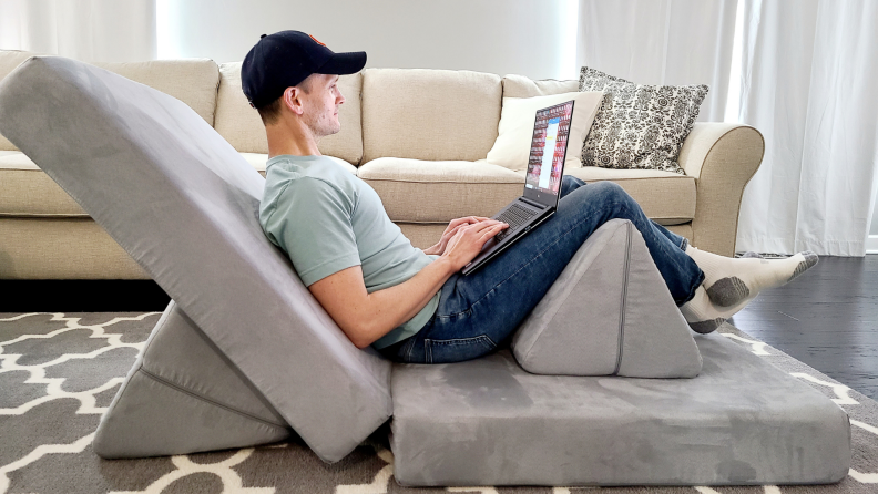 A person reclines using the Nugget couch.