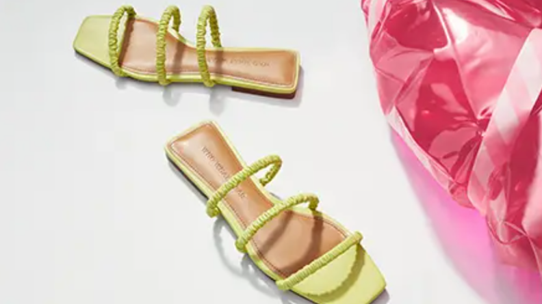 Bright green strappy sandals next to a pink puffy thing.