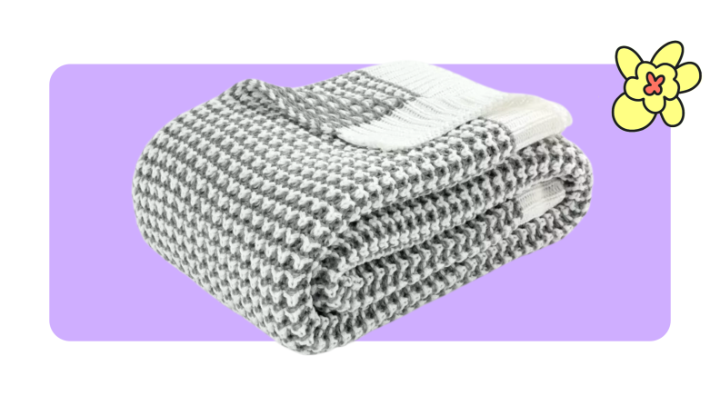 Gray and white knitted Lush Decor woven throw blanket folded into a square.