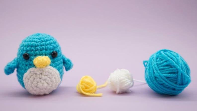 Crocheted penguin and yarn.