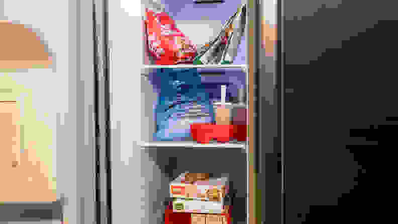 A shot of the interior of the Samsung RS27T5200SR's freezer compartment, with some frozen food items included for scale. The stack of TV dinners takes up about two-thirds the width of a shelf.