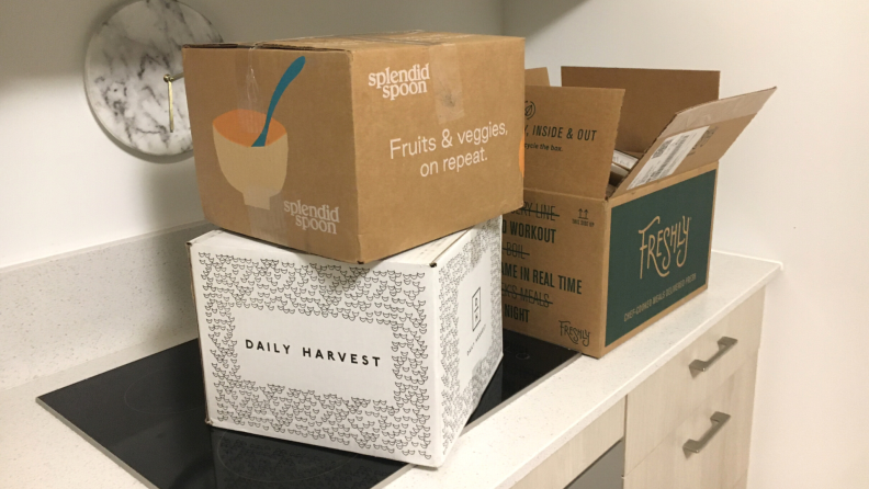 Boxes for Snap Kitchen, Freshly, and Daily Harvest on a kitchen counter