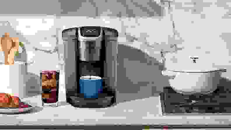 A grey Keurig Elite single-serve coffee maker on a cream kitchen counter.