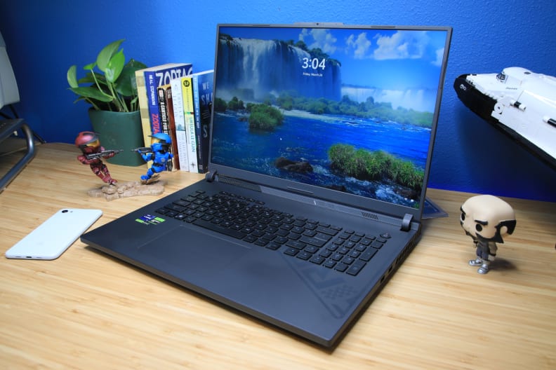 A black laptop on a light brown desk