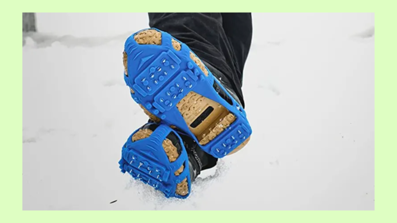 A person crosses their feet together in the snow wearing cleats.